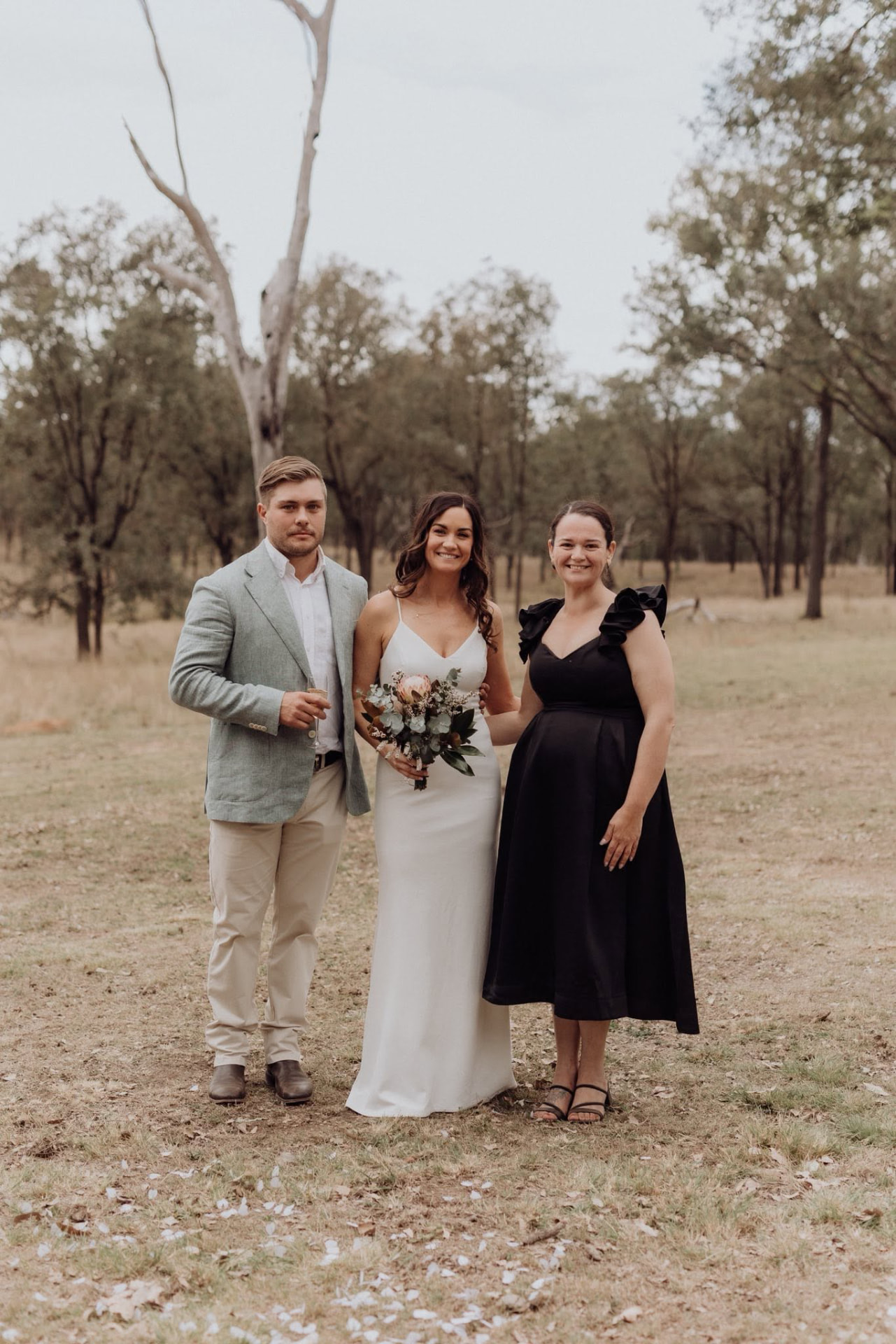 Simone with a newly married couple beneath the gum trees