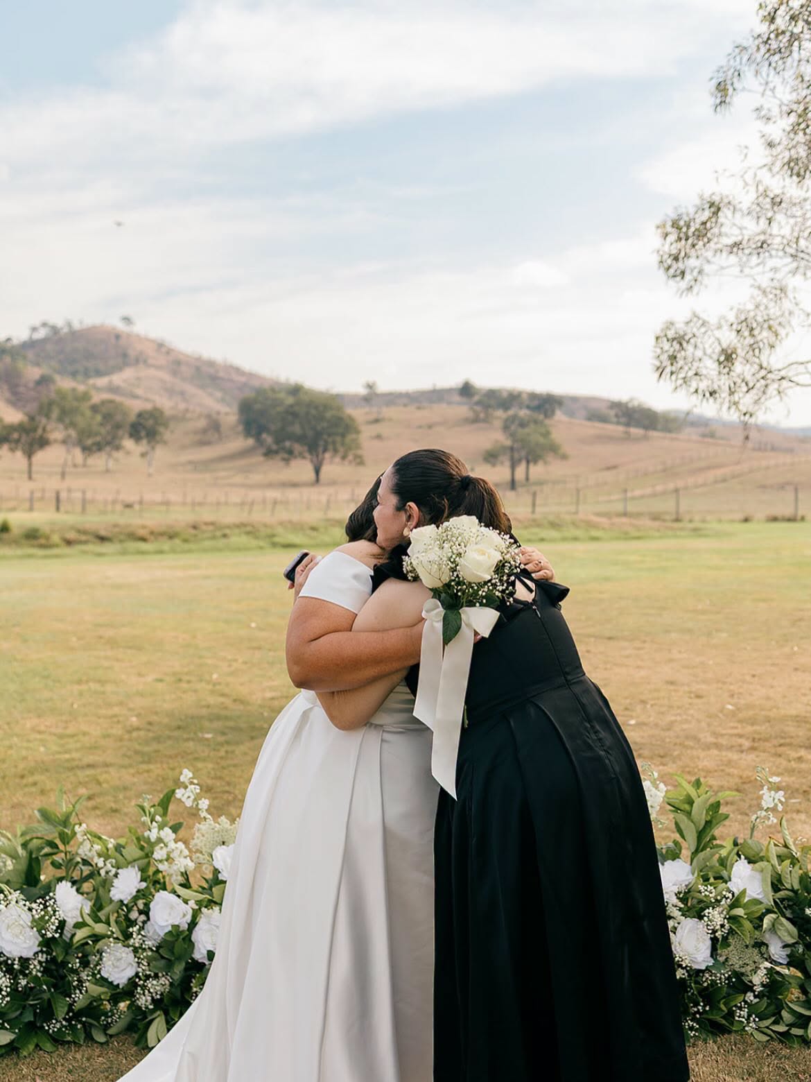 Simone hugging a bride after the ceremony in a country paddock