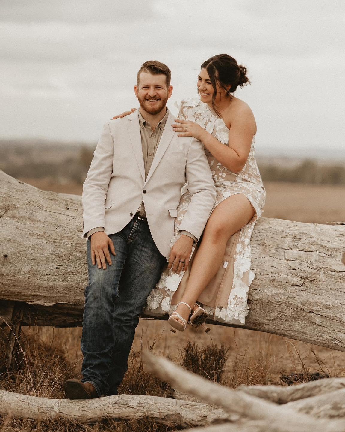 Bride and groom laughing together on a fallen log