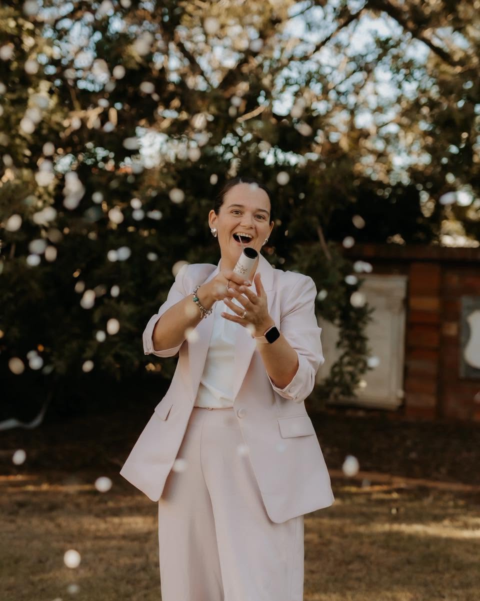 Simone laughing as she sets off a confetti cannon at a wedding